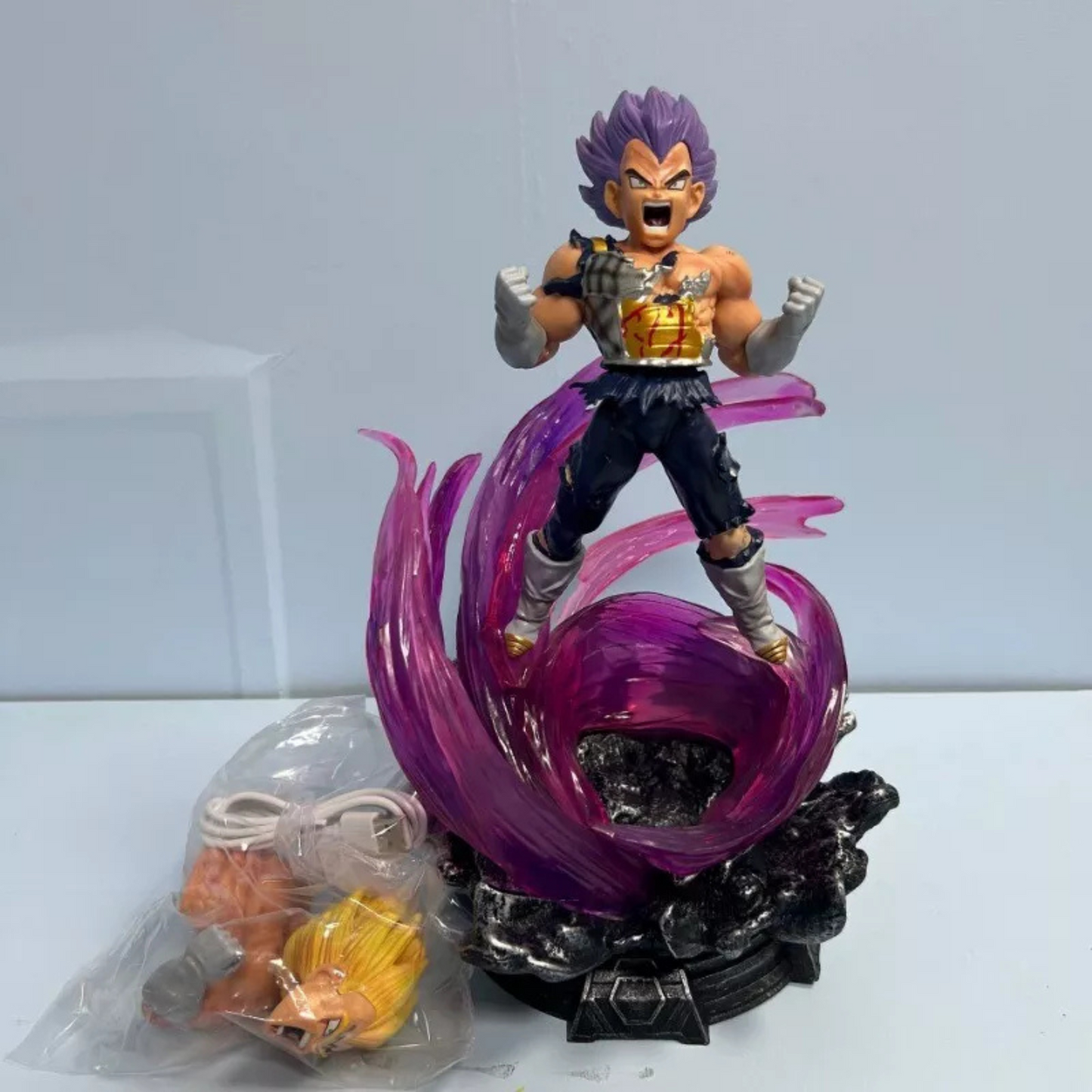 Dragon Ball Z action figure of Super Saiyan Ultra Instinct Vegeta with LED base, purple energy swirl, and interchangeable heads.