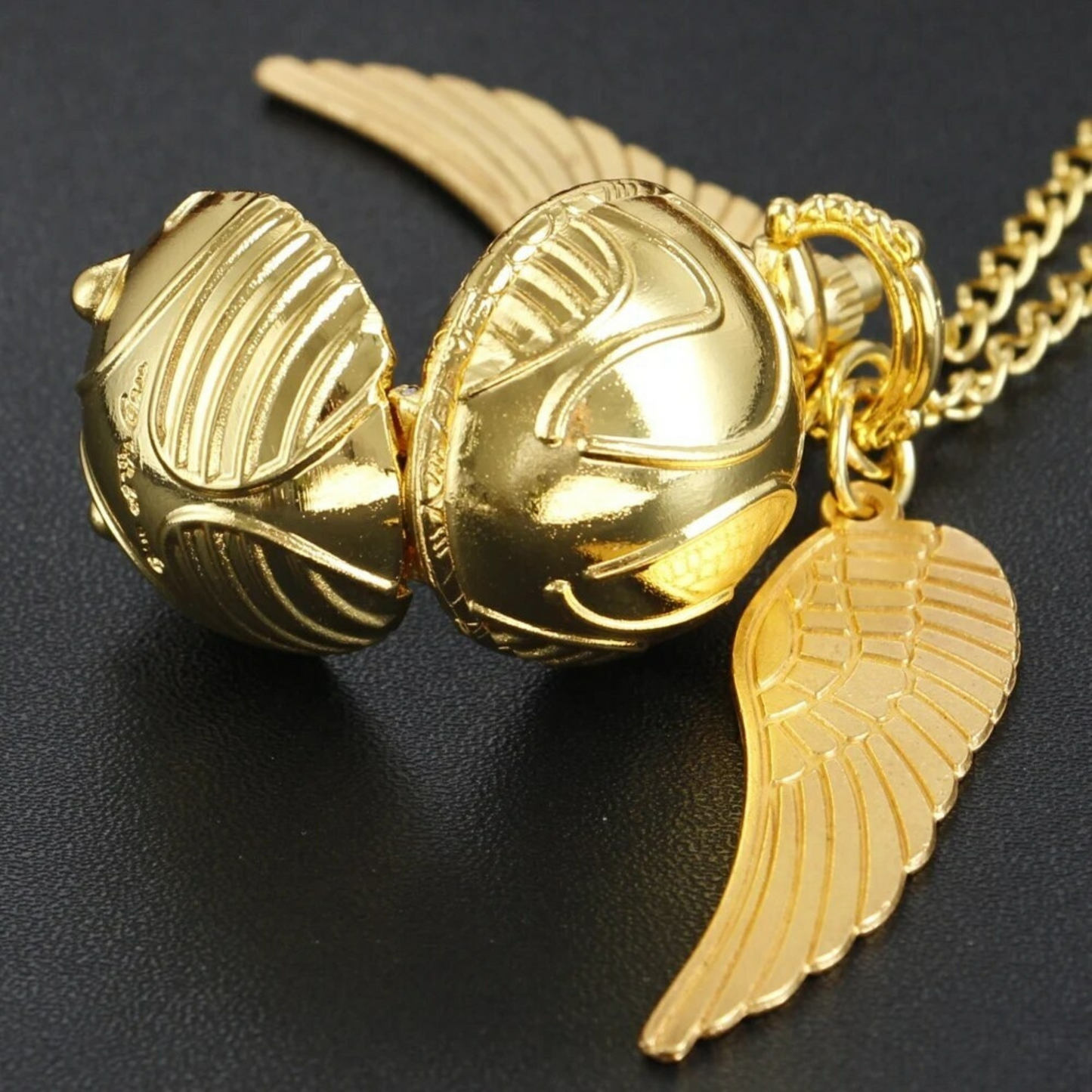 Golden Snitch pocket watch necklace with wings – Harry Potter themed collectible on golden mirror
