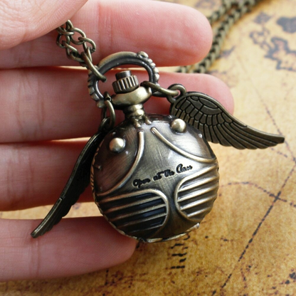 Golden Snitch pocket watch necklace with wings – Harry Potter themed collectible on golden mirror